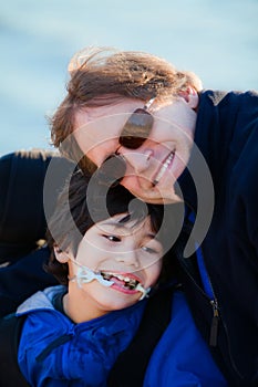 Father sitting with disabled son along lake shore