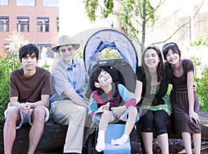 Father sitting with his biracial children and disabled son