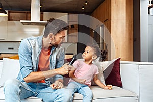 Father and small child girl playing with microphone