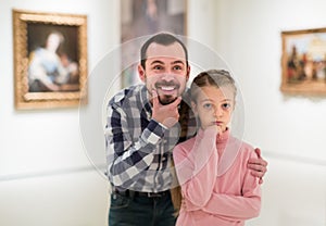 Father and small daughter exploring pictorial art