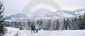 Father with small daughter on a walk outdoors in winter nature, Tatra mountains Slovakia.