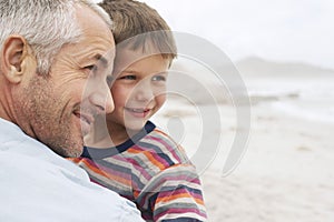 Father and son (5-6) on beach close-up