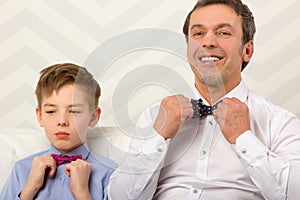 Father and son adjusting bowties