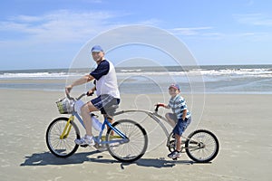 Father and son on alley cat bike at the beach