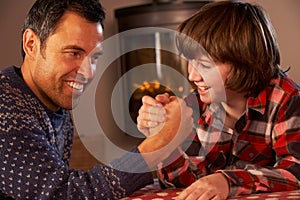 Father And Son Arm Wrestling By Cosy Log Fire