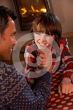 Father And Son Arm Wrestling By Cosy Log Fire