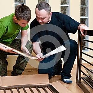 Father and son assemble crib photo