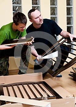 Father and son assemble crib photo