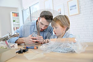 Father and son assembling an aeroplane toy