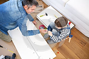 Father and son assembling furniture