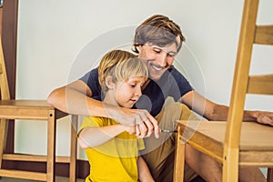 Father and son assembling furniture. Boy helping his dad at home. Happy Family concept