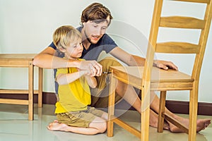 Father and son assembling furniture. Boy helping his dad at home. Happy Family concept