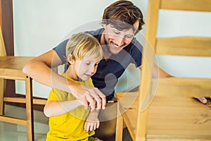 Father and son assembling furniture. Boy helping his dad at home. Happy Family concept