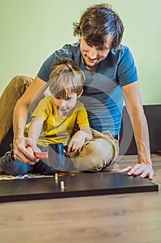 Father and son assembling furniture. Boy helping his dad at home. Happy Family concept