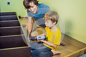 Father and son assembling furniture. Boy helping his dad at home. Happy Family concept