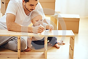 Father and son assembling furniture at home