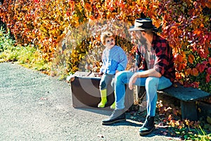 Father and son in autumn park having fun and laughing.