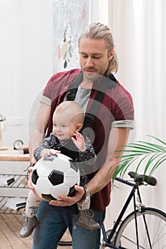 father with son in baby sling holding a