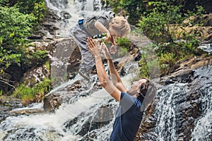 Father and son in the background of beautiful cascading Datanla waterfall In the mountain town Dalat, Vietnam