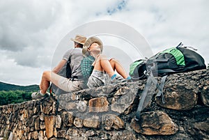 Father and son backpacker traveler rest together sitting on old
