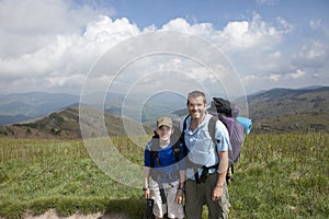 Father and son backpacking in mountains