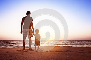 Father and son beach sunset holidays concept