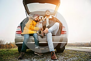 Father and son with beagle dog siting together in car trunk. Long auto journey break photo