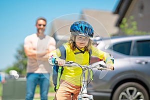 Father and son on the bicycle. Father and son riding a bike in summer park. Kid learning to riding bicycle. Father and