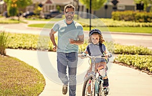 father and son on bicycle at fathers day. active father setting a example for fathers son. fathers parenting with son