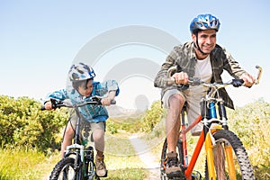 Father and son biking through mountains