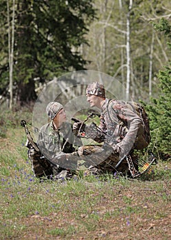 Father and son bow hunting in woods