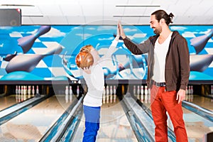 Father and son in bowling center