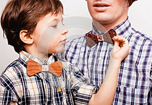 Father with son in bowties on white background,