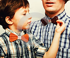 Father with son in bowties on white background, casual look