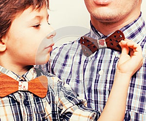 Father with son in bowties on white background, casual look