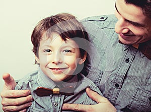 Father with son in bowties on white background, casual look