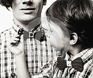 father with son in bowties on white background, casual look fami