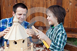 Father and son building a bird house or feeder