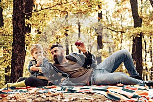 Father and son camping. Man with beard, dad with young son in autumn park. Happy joyful father with a cute son vacation