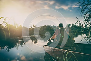 father and son catch fish from a boat at sunset