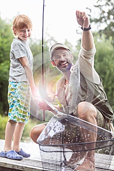 Father and son catching fish in pier