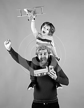 Father and son. Child pilot aviator with airplane dreams of traveling on blue background. Portrait of happy father