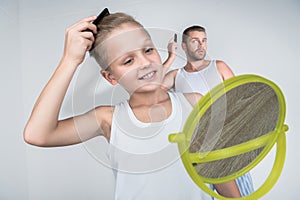 Father and son combing hair