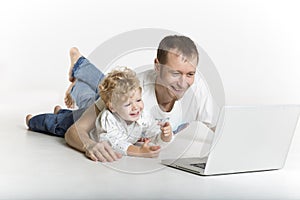 Father and son are on computer on the floor