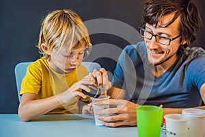 Father and son conduct chemical experiments at home. Home made slime