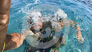 Father and son couple have fun together playing at sea - family young and adult laugh and joke in ocean water at the beach during