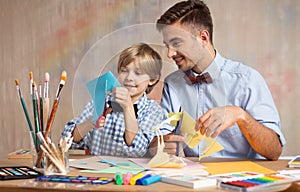 Father and son cutting paper