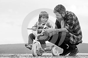 Father and son cycling with kids bike outdoor. cute Little boy learn to ride a bike with his daddy. Dad teaching son to