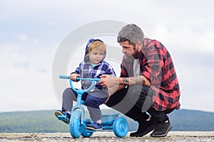 Father and son cycling with kids bike outdoor. cute Little boy learn to ride a bike with his daddy. Dad teaching son to
