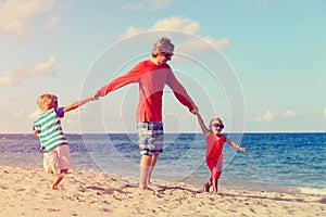 Father with son and daughter play at beach